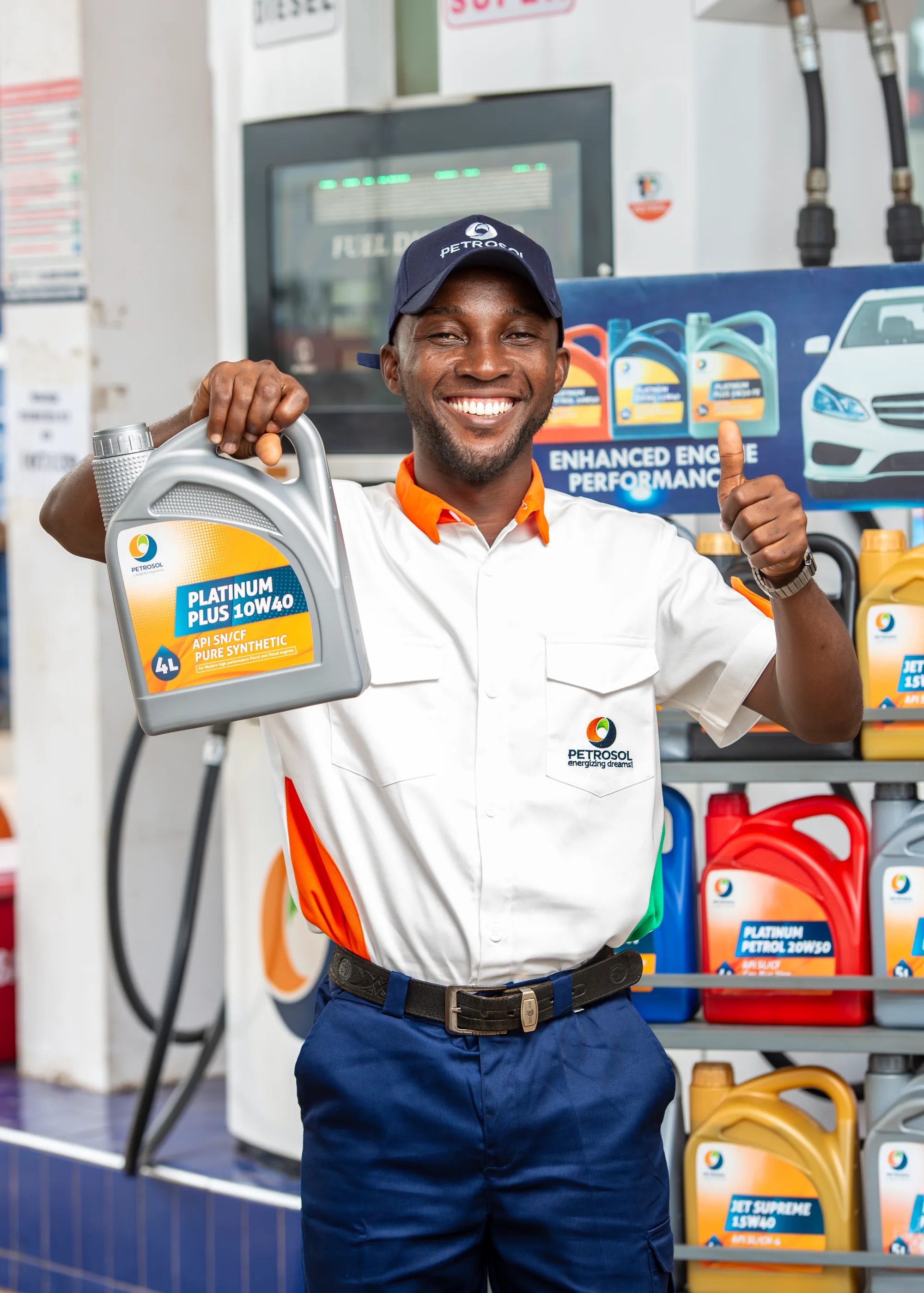 A PETROSOL attendant holding up Platinum Plus 10W40, the lubricants shelf stocked behind him