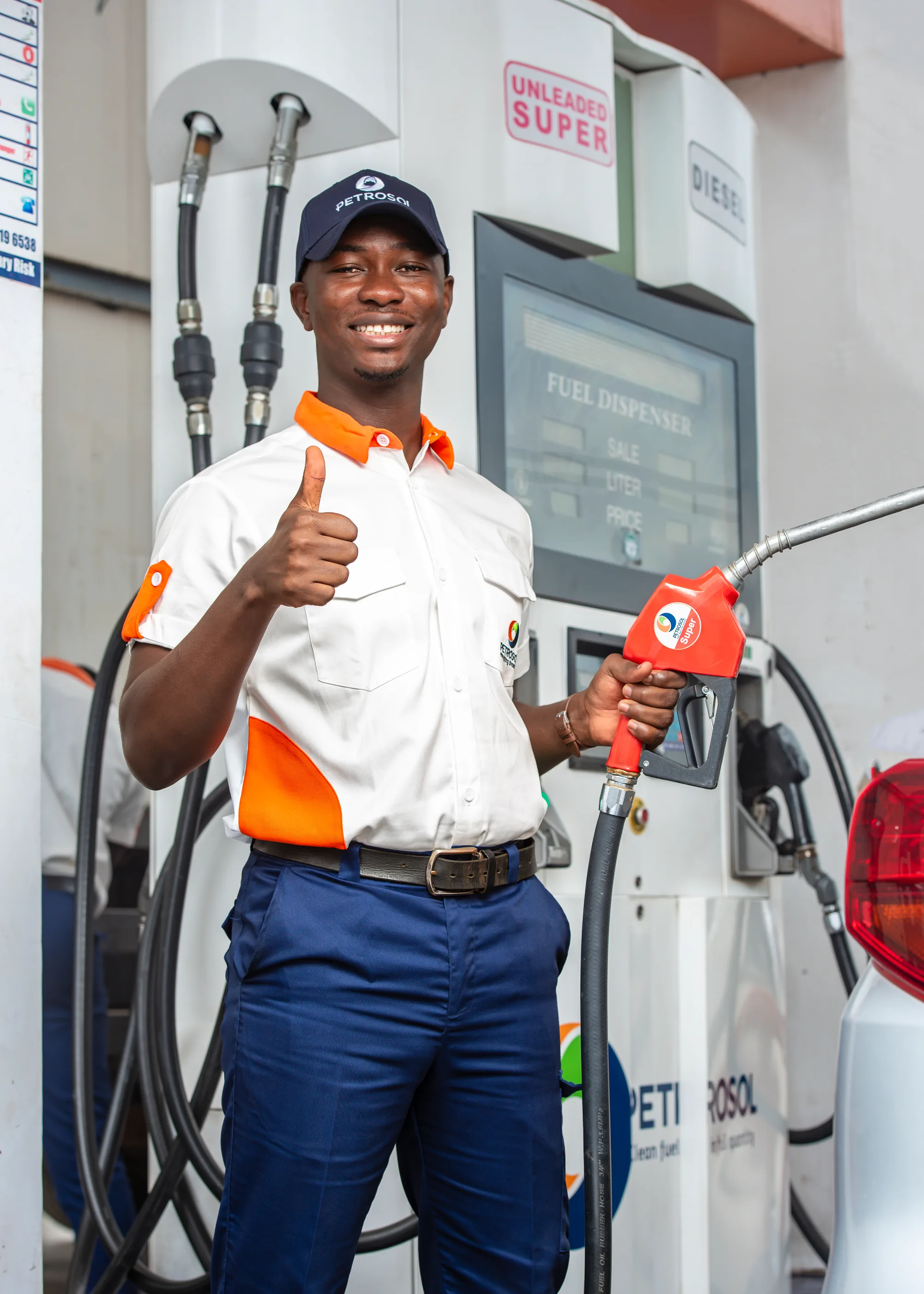 A PETROSOL forecourt attendant at the pump, holding a Super nozzle and giving a thumbs up
