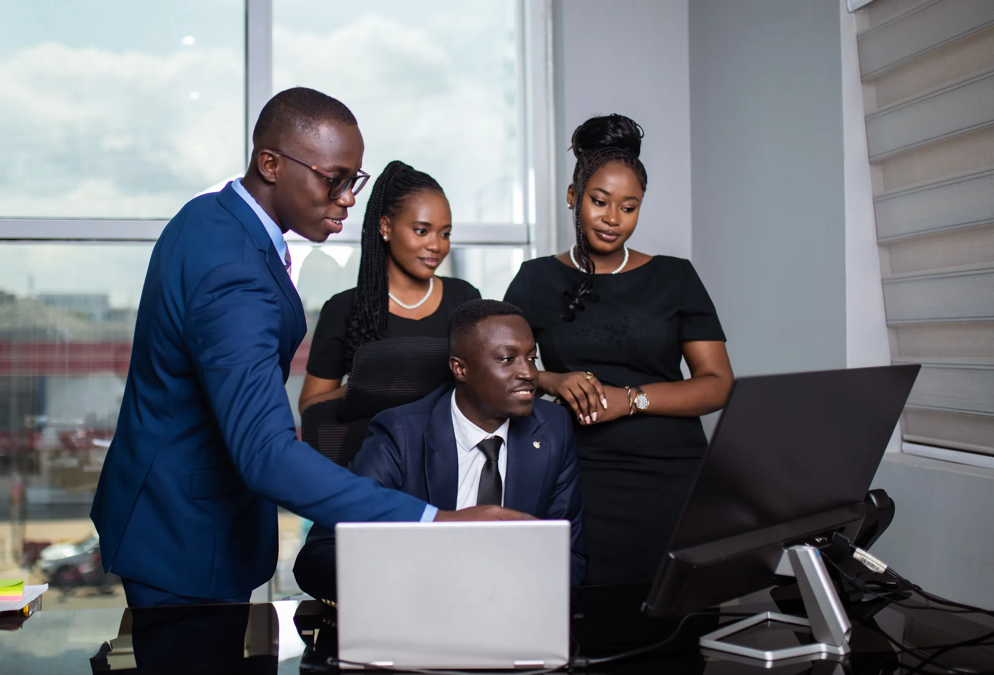 Four PETROSOL professionals collaborating around a computer in the office