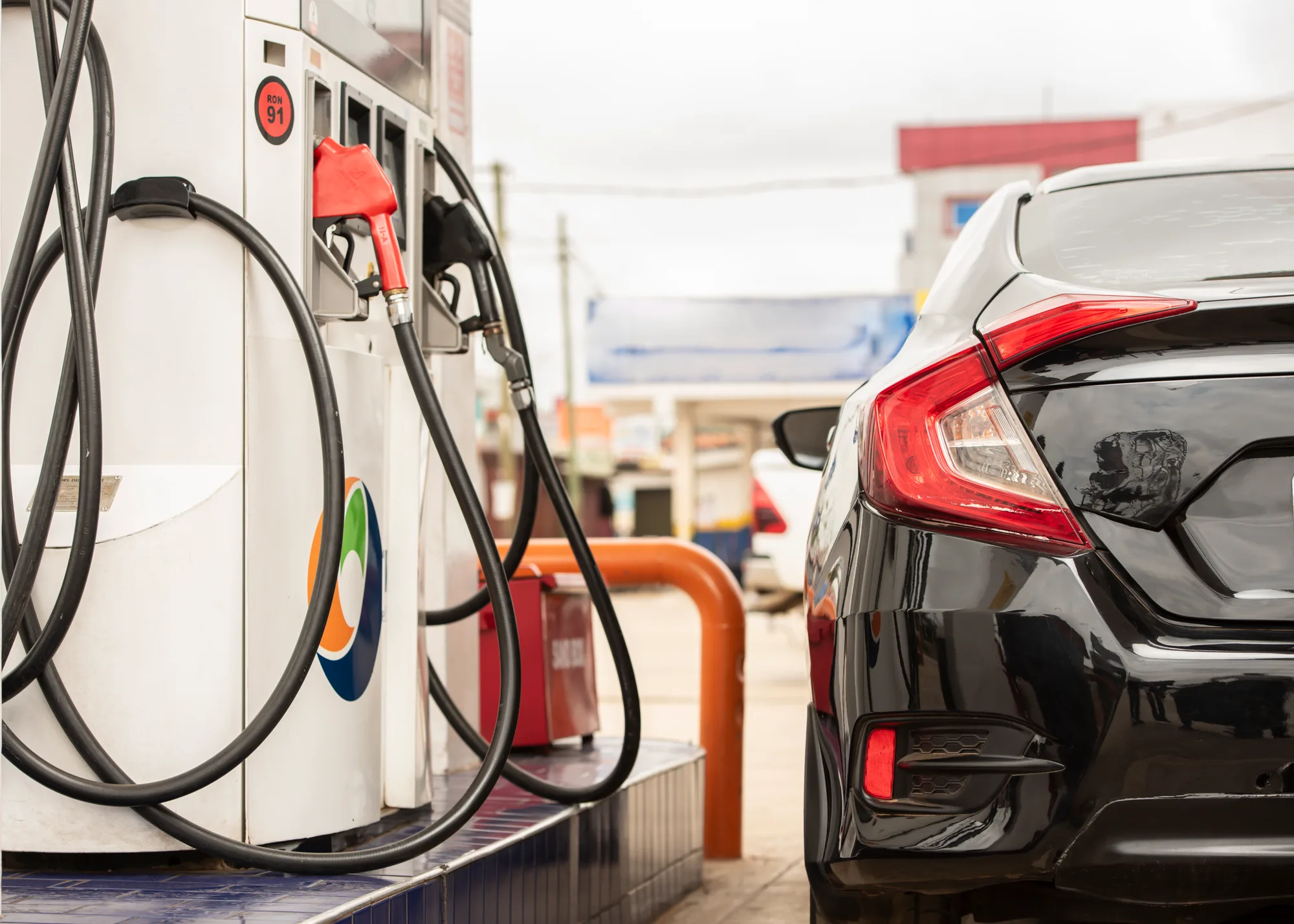 PETROSOL dispenser nozzles on the island, with a car drawn up at the pump