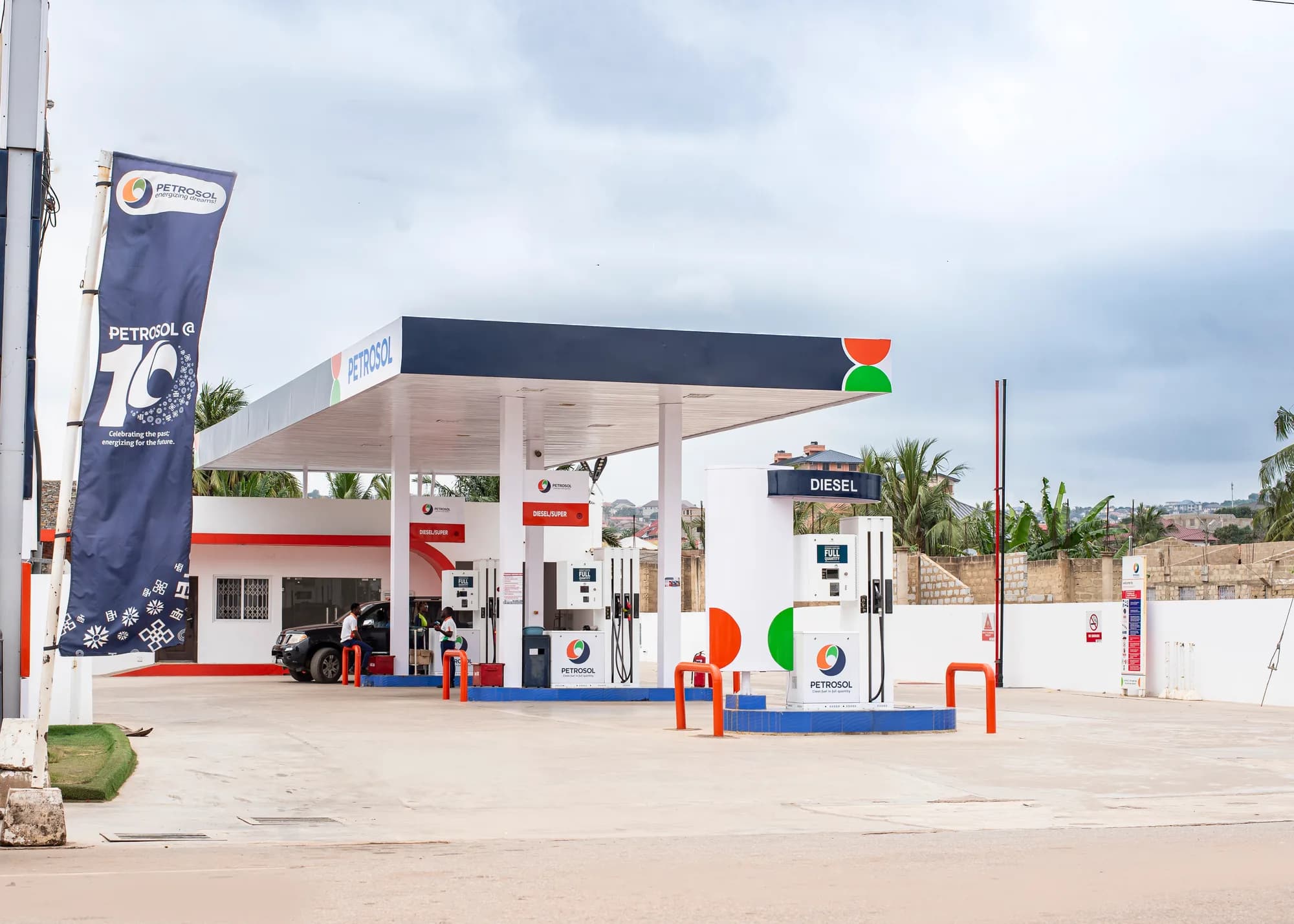 A clean, empty PETROSOL forecourt under the branded canopy, with the diesel island and safety bollards in view