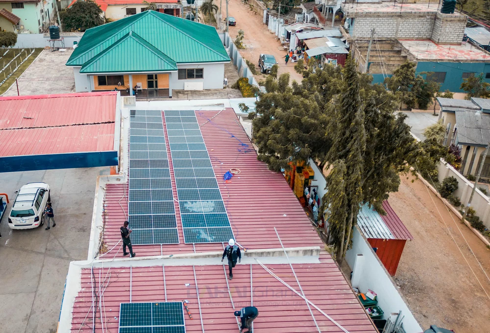 Technicians installing solar panels on the roof of a PETROSOL station